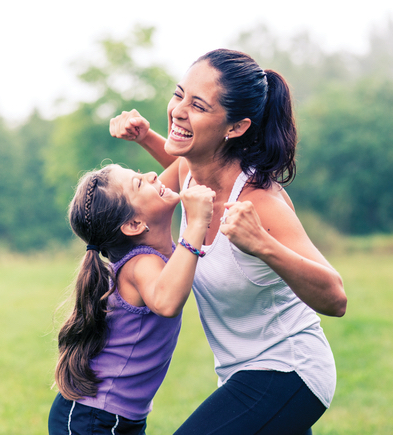 A woman and her young daughter smiling and laughing